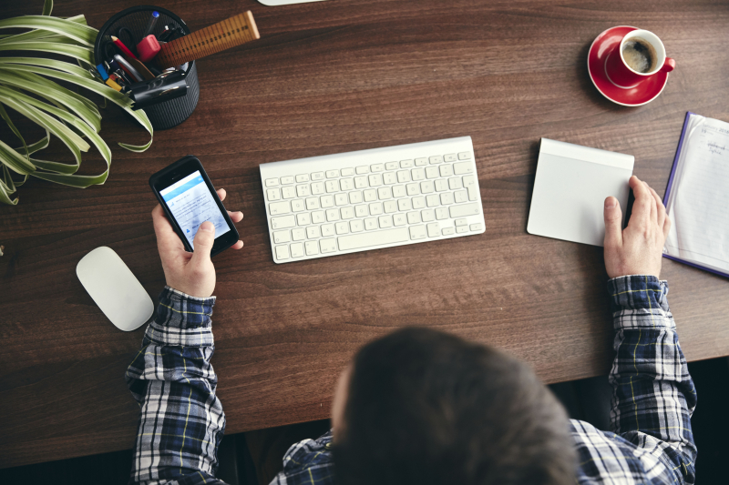 Overhead 2-view-of-a-man-seated-at-a-desk-using-a-mo-XK7P9W2